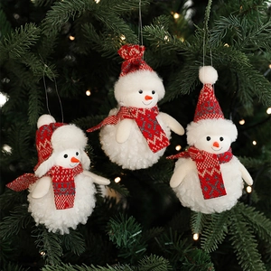 Three plush snowman ornaments in red and white hanging on a Christmas tree branch