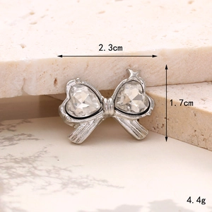 Detailed macro view of a silver bow-shaped zinc alloy charm with heart gemstones
