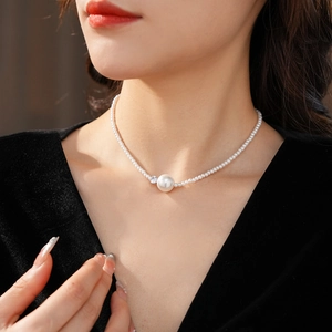 Primo piano della collana di perle con una grande perla tonda e uno zircone lucente