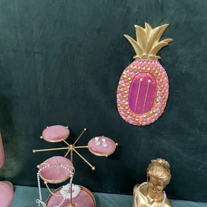 Pink velvet jewelry organizer stand with gold pineapple wall hook and pearl necklace display