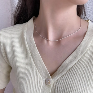 Close-up of minimalist 925 sterling silver snake chain necklace on female model neck