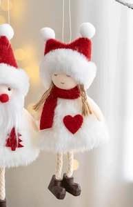 Close-up of plush girl doll Christmas tree hanging ornament with red hat and white dress