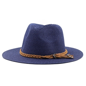 Detail of dark blue fedora straw hat with brown braided band and metal buckle accents