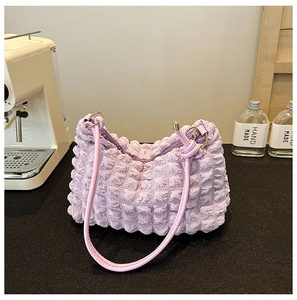 Detailed texture of the purple bubble pleated fabric on a stylish underarm handbag