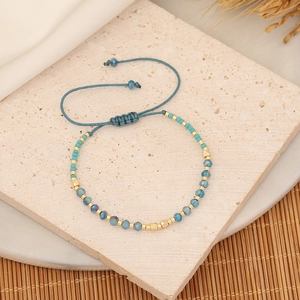 Handmade woven crystal bracelet with blue beads and turquoise on a textured stone base