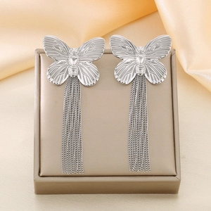 Detailed view of silver butterfly tassel earrings on champagne satin and jewelry box