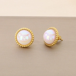 Macro shot of gold-plated stud earrings with iridescent opal stones and beaded edges
