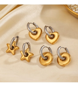 Trois paires de boucles d'oreilles en acier avec charms cœur et étoile sur du satin