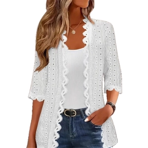 Detail of white lace cardigan showing eyelet embroidery and wavy scalloped sleeve edges