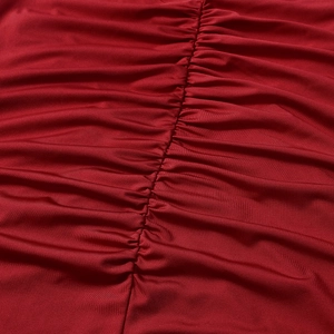 Macro detail of red ruched fabric showing elegant pleated texture and elastic material