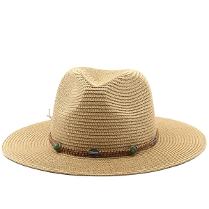 Detail of bohemian straw hat showing woven band with green beads and vintage metal buckle