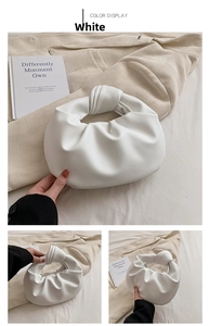 Detail of white pleated cloud bag showing knotted handle and soft faux leather texture