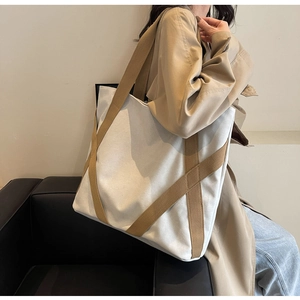Detail of reinforced canvas tote handles showing stitching quality and khaki strap design