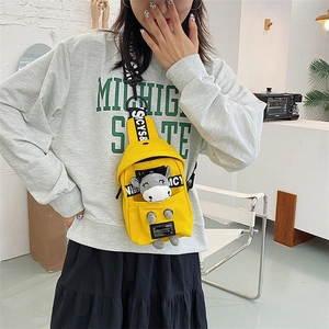 Detailed view of bright yellow canvas chest bag with a cute plush calf doll ornament