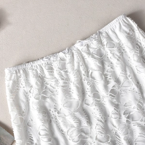Détail du tissu blanc usé avec taille élastique et textures ajourées effilochées