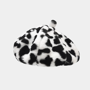 Gros plan détaillé d'un béret en fausse fourrure douce avec un motif de vache noir et blanc