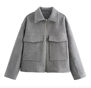 Détail de la veste en laine grise avec fermeture éclair et grandes poches plaquées