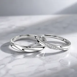 Detailed close-up of S999 sterling silver couple rings with Mobius design and tiny diamonds