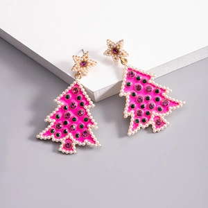 Detail view of pink Christmas tree earring with purple rhinestones and pearl border
