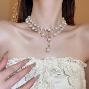 Close-up of double-layer water drop pearl necklace worn on neck with silver chain detail