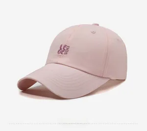 Detail showing 3D purple embroidered logo on light pink quick-dry baseball cap