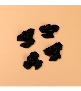 Dettaglio di quattro fermagli per spille in smalto nero con texture antiscivolo e chiusura a farfalla