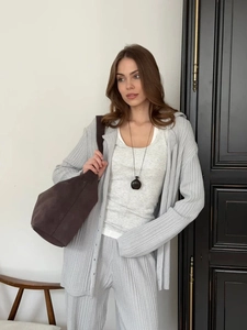 Detail of grey knitted lounge set featuring ribbed texture and stylish oversized brown bag