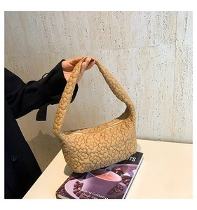 Close-up of beige quilted shoulder bag with 3D floral texture and puffy cloud design