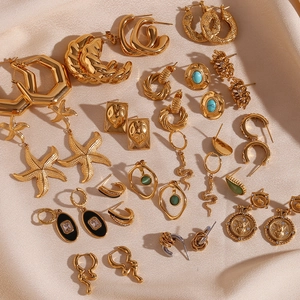 Flat lay of vintage 18K gold plated earrings with turquoise and black enamel details