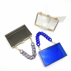 Transparent acrylic box clutch bags with gold metal trim and chunky chain handles