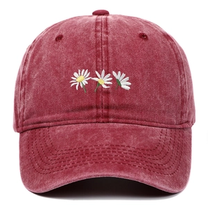 Dettaglio cappello baseball in cotone lavato bordeaux con ricamo di margherite bianche