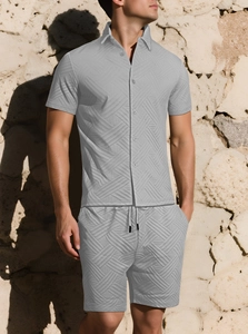 Dettaglio del completo uomo grigio chiaro con trama jacquard 3D e camicia con bottoni