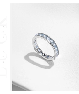 Macro detail of eternity ring with square-cut light blue gemstones in silver setting