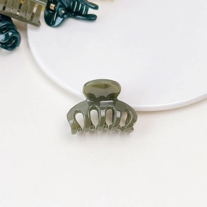 Close-up of a mini army green jelly hair claw clip with smooth acrylic texture
