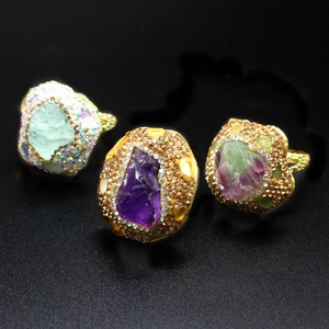Detailed shot of vintage gold rings with natural amethyst and crystals on black background