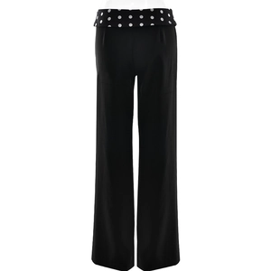 Detail view of women's black trousers back featuring a white polka dot fold-over waistband