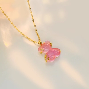 Detail of pink resin bear pendant with gold star zircon and sleek water wave chain