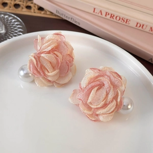 Detail of pink chiffon flower earrings with large pearls on elegant white porcelain