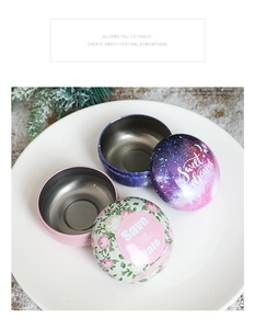 Detail of round tin wedding candy boxes with floral and starry motifs in a festive setting