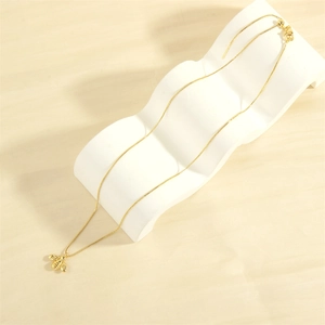Macro detail of a minimalist 18K gold-plated bee pendant with fine texture and box chain