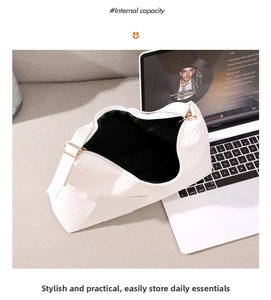 Top view of white quilted shoulder bag with spacious black interior for a laptop