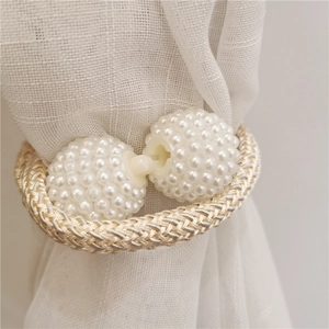 Close-up of plush bear curtain tieback with faux pearls and woven rope on white voile