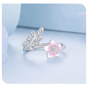 Macro detail of silver cherry blossom ring with pink enamel petals and white zircons