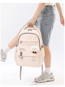 Detail of light beige student backpack with cloud plush charm and side storage pocket
