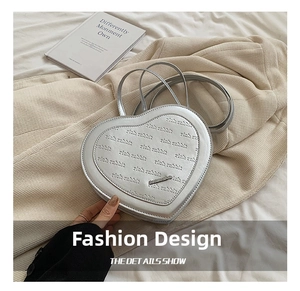 Detail of silver heart-shaped handbag with rich rabbit letter embossing and metal logo