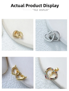 Détail de pendentifs en forme de cœur or et argent avec zircons et breloques en croix
