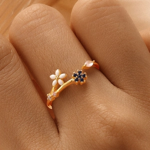 Macro view of a gold-tone floral branch ring with enamel flowers and colorful gemstones