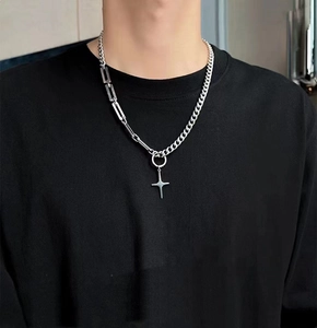 Detail of silver star pendant necklace on model with Cuban link and rectangle chain
