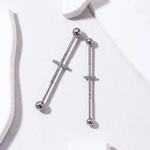 Barbell industriel en acier argenté avec croix sertie de cristaux sur fond de pierre