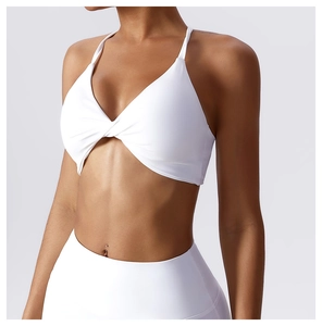 Detail of white yoga bra with twist front design and thin halter straps for fitness